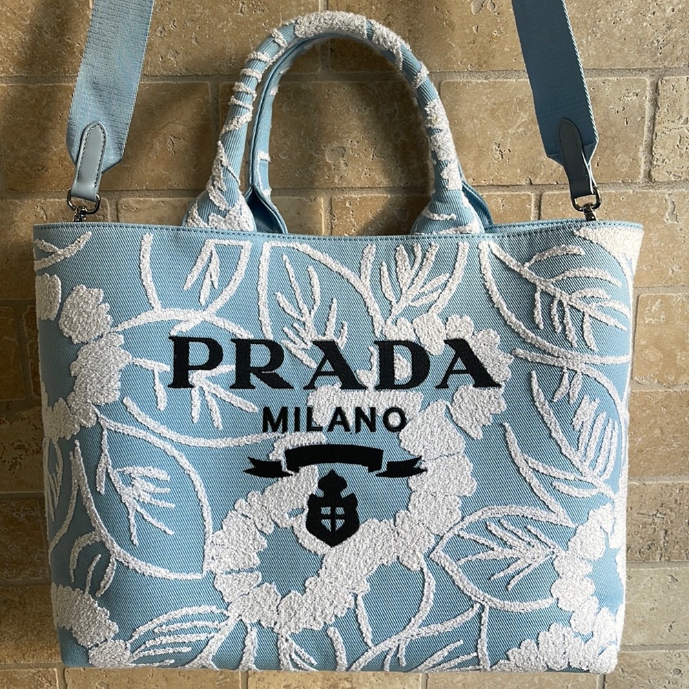 This Prada embroidered drill tote features an enlarged Prada logo on the front.